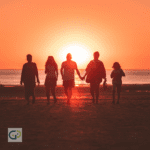 A family walking together on a beach at sunset